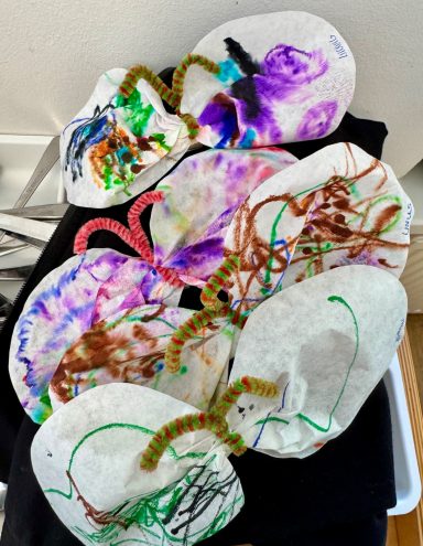 Schmetterlinge voller Farben Bunte, bemalte Papierschnitte in Form von Schmetterlingen mit bunten Garnen.