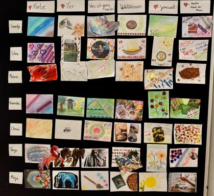 Eine Wand mit verschiedenen bunten Kunstwerken und Zeichnungen in mehreren Reihen angeordnet.