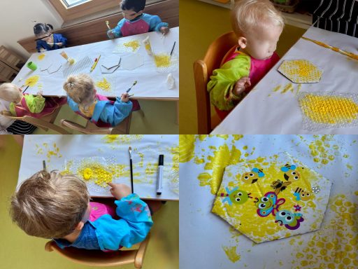 Kinder malen mit gelber Farbe auf einem Tisch, umgeben von Kreativmaterialien.