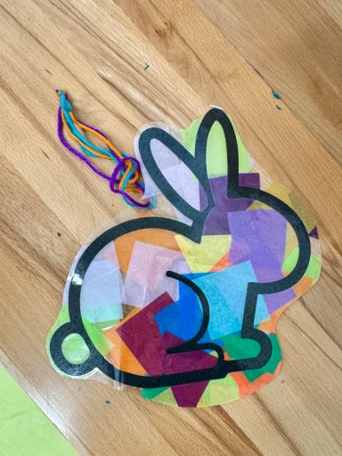 Bunte Bastelarbeit in Form eines Hasen aus transparentem Papier auf einem Tisch.